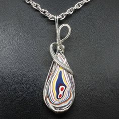 "Fordite Wire Wrapped Jewelry Description:  *Designer Fordite Detroit Agate Cabochon: 30mm x 20m Teardrop Shaped *Pendant Approximate Size: 2 1/2\" long including bail x 1\" at widest point  *Free Rope Chain *Free Domestic Shipping - Arrives in Gift Box - Gift Wrapping Available The contemporary wire wrap jewelry is hand wire sculptured using sterling silver wire around the recycled Fordite Detroit Agate cabochon to form this collector's item handmade wire wrap pendant statement necklace. The ba Wire Wrap Agate Slice, Turquoise Agate Wire Wrapped Necklace, Wire Wrapped Agate Pendant Jewelry, Adjustable Wire-wrapped Agate Beaded Necklace, Fordite Jewelry, Luxury Wire Wrapped Agate Necklace, Wire Wrap Jewelry, Wire Wrap Pendant, Bijoux Fil Aluminium