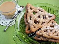 some cookies are on a green plate next to a cup of coffee and a spoon