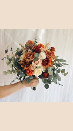 a person holding a bouquet of flowers in their hand