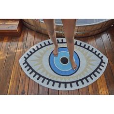 a person standing on top of a wooden floor next to a blue and white rug