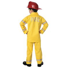 a child wearing a fireman costume standing with his hands on his hips and back to the camera