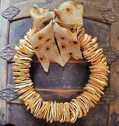 a close up of a wreath on a door with a bow hanging from the front