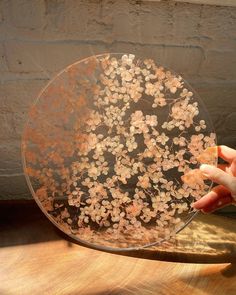 a person holding a glass plate with flowers on it