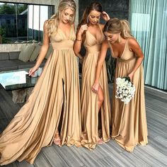 three women in long dresses standing next to each other on a wooden flooring area