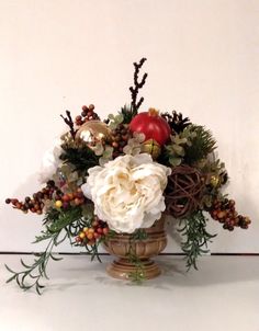 a vase filled with white flowers and greenery