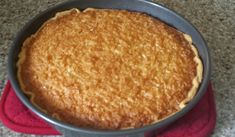 a cake in a pan sitting on top of a red towel next to a stove