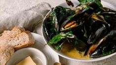 a bowl of mussels and bread on a table