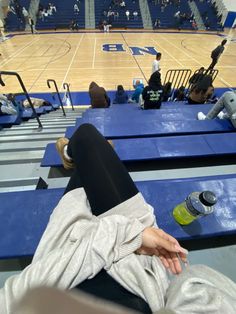 a person laying on the bleachers at a basketball game