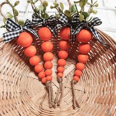 four oranges are arranged on a wicker basket with black and white ribbon tied around them