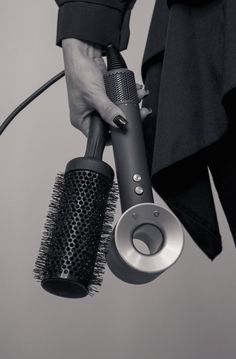 a woman holding a hair dryer and brush