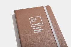 a brown notebook with the pantone mocha mouse on it's front cover