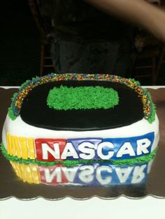 a cake that is decorated with grass and the words nascar on it, sitting on a table