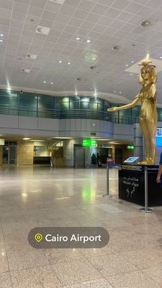 a large gold statue in an airport lobby