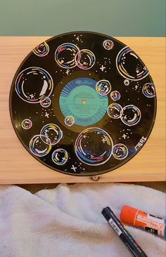 a black plate with bubbles on it sitting on a table next to markers and pens