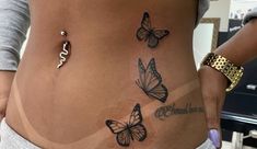 a woman's stomach with three butterflies on her belly and the word love written in cursive writing