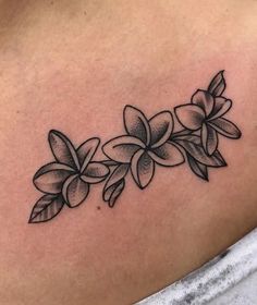 a black and white photo of flowers on the back of a woman's shoulder