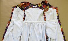 three pieces of white clothing with colorful flowers on them