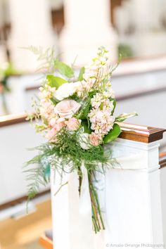 a bouquet of flowers sitting on top of a church pew