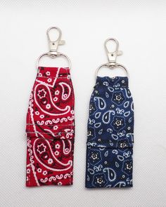 two keychains with different designs on them, one is red and the other is blue