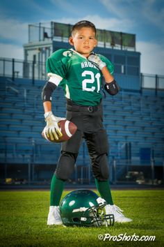 a young boy in uniform holding a football