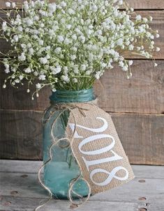 a mason jar filled with baby's breath flowers on top of a wooden table