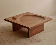 a wooden table with a bowl on the top and two holes in the middle for serving food