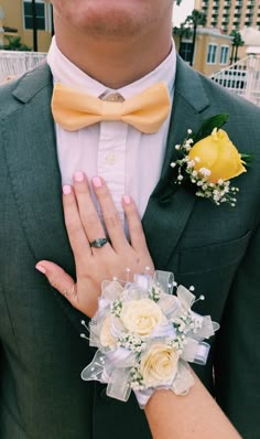 a close up of a person wearing a suit and tie with flowers on his lapel