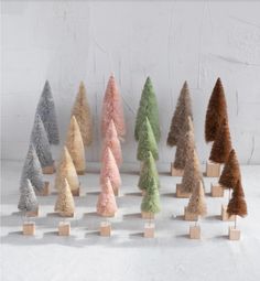 a group of small wooden trees sitting on top of a white table next to each other