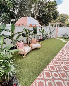 two lawn chairs and an umbrella in a backyard