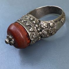 Antique ~ Very well Handmade ~ old Yemeni silver ring ~ Featuring a large central amber or amber resin set on an closed back bezel setting with wire and beaded border ~ Unsigned but acid tested for atleast 800 silver . Dates first half or 20th century Measurements : Ring can fit size 8 - 8 1/2 . Front is 1/2 inches in max diameter x 5/8inches in height Weighs 9 grams on my weighing scale . Condition : Good old condition ,with heavy age patina to silver and central bead ~ No cracks /chips to cora Unique Brown Jewelry For Ceremonial Occasions, Unique Carved Ring Jewelry, Vintage Carved Amber Jewelry, Vintage Amber Carved Jewelry, Traditional Amber Jewelry With Carved Details, Bohemian Carved Ring Jewelry, Bohemian Amber Sterling Silver Rings, Bohemian Carved Amber Jewelry, Handmade Silver Rings For Rituals