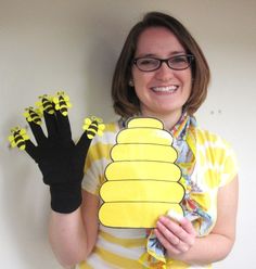 a woman in glasses holding up a yellow and black glove