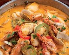 a bowl filled with seafood and clams on top of a table