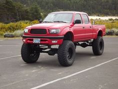 a red pick up truck parked in a parking lot