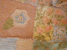 an old patchwork quilt with flowers on it