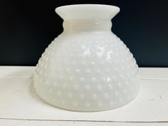 a white vase sitting on top of a table