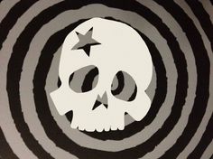 a skull with stars in the middle on a black and white striped background that appears to be circular