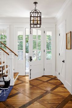 a foyer with wooden floors and white doors