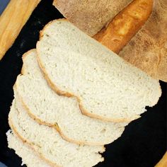 a loaf of white bread sitting on top of a black cloth next to a piece of bread