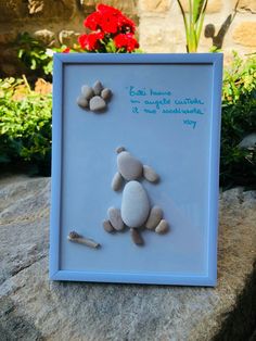 a blue frame with some rocks in it and a small dog's paw on top