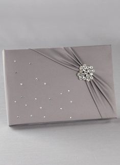 a gray box with a silver bow and some pearls on it's side,