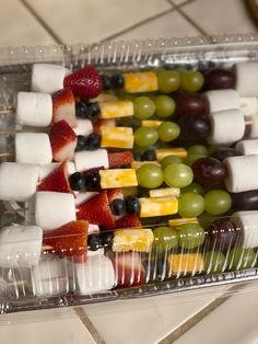 fruit and marshmallows are arranged in a tray