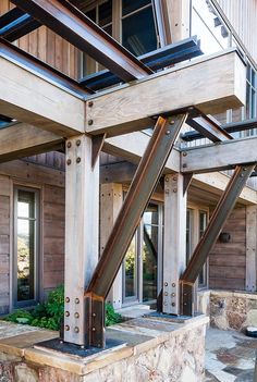 an outside view of a building with wooden walls and metal beams on the front porch