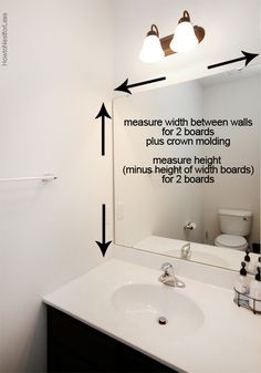 a bathroom with a mirror, sink and two lights on the wall next to it