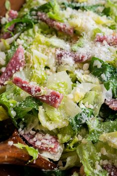 a salad with lettuce, bacon and parmesan cheese is shown here