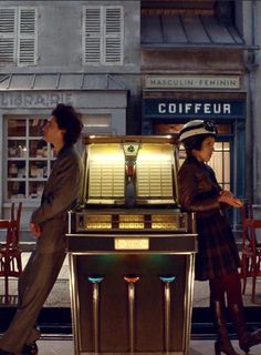 two people walking past a juke machine on the street