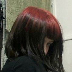 a woman with red hair is looking in the mirror