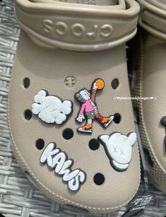 a pair of crocs with stickers on them sitting on a wicker mat