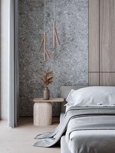 a modern bedroom with concrete walls and white linens on the bed, side table