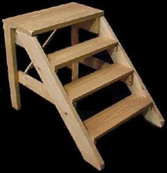 a wooden step stool sitting on top of a black floor