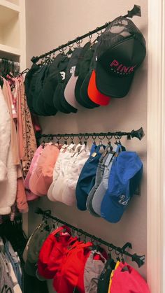 there are many hats and shorts hanging on the rack in this closet, but no one is wearing them